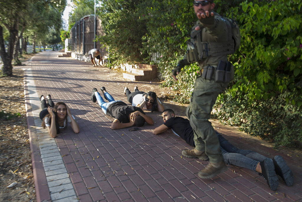 Varios israelíes se tiran al piso al sonar una alarma anunciando la llegada de cohetes provenientes de Gaza el 16 de mayo del 2021 en Ashkelon, al sur de Isr21. (AP Photo/Heidi Levine)