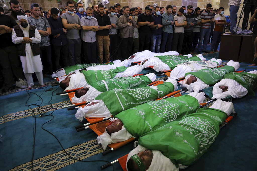 Palestinos presencian los funerales de 13 milicianos de Hamas muertos en los enfrentamientos con Israel, el jueves 13 de mayo de 2021, en Gaza. (AP Foto/Adel Hana)
