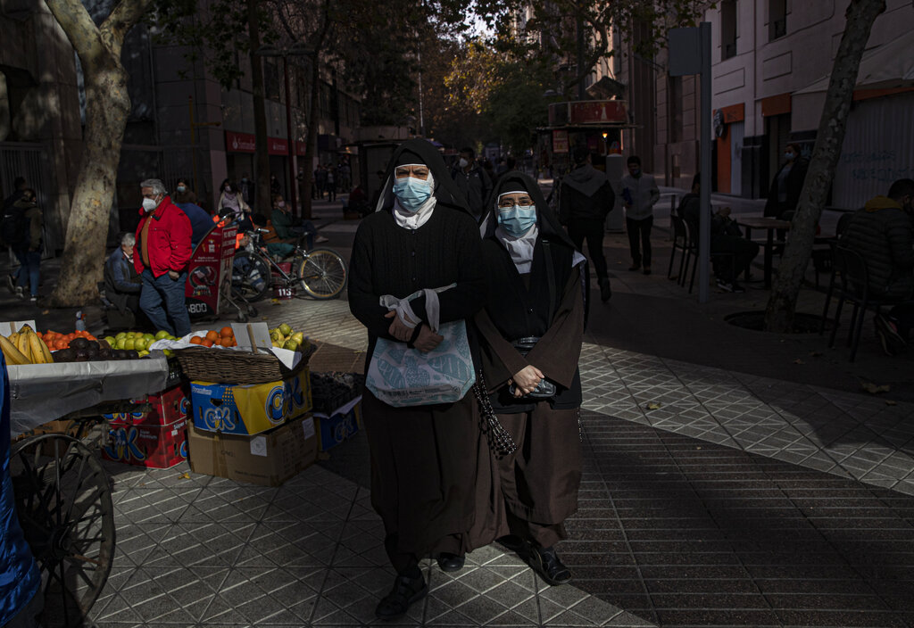 Monjas caminan por el Paseo Huérfanos, una calle peatonal en Santiago, Chile, el viernes 28 de mayo de 2021, en medio de la nueva pandemia de coronavirus. (AP Foto/Esteban Felix)