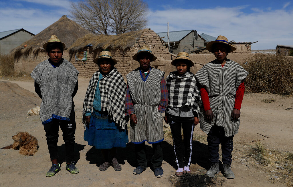 Miembros de la familia Choque, de izquierda a derecha, José, Evarista Flores, Rufino, Abelina y Abdón, posan para una foto en la comunidad indígena Urus del Lago Poopó en Puñaca, Bolivia, el domingo 23 de mayo de 2021. (AP Foto/Juan Karita)