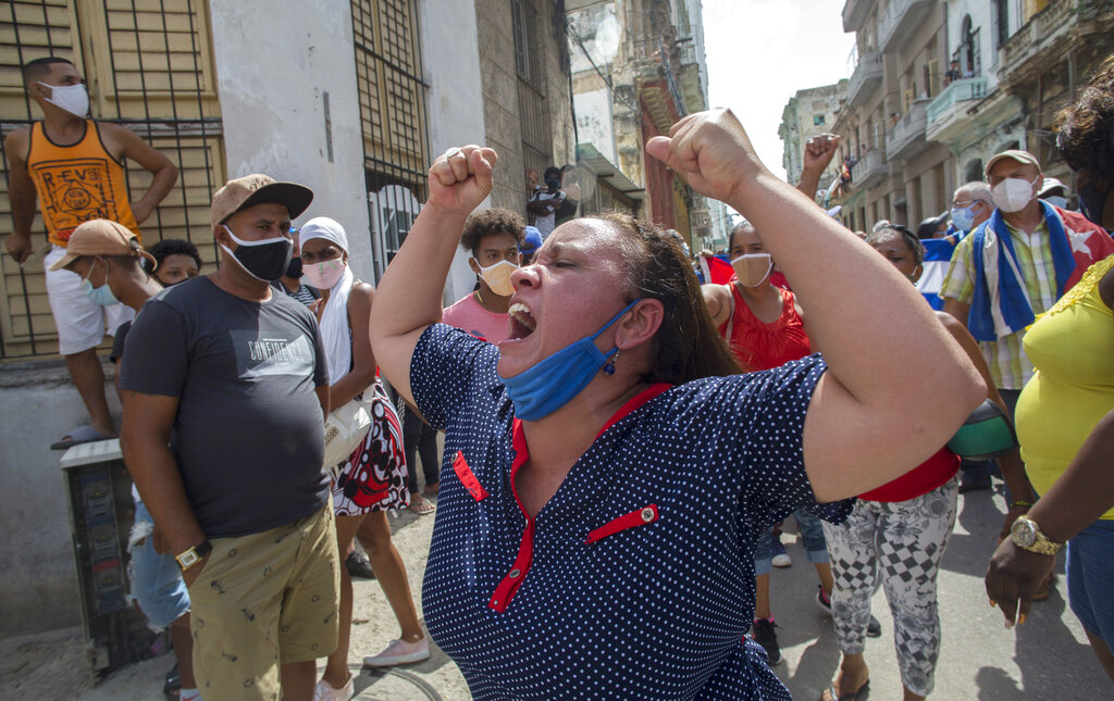 Una mujer grita consignas progubernamentales mientras manifestantes antigubernamentales marchan en La Habana, Cuba, el domingo 11 de julio de 2021. Cientos de manifestantes salieron a las calles en varias ciudades de Cuba para protestar contra la actual escasez de alimentos y los altos precios de los productos básicos en medio de la pandemia del coronavirus. AP