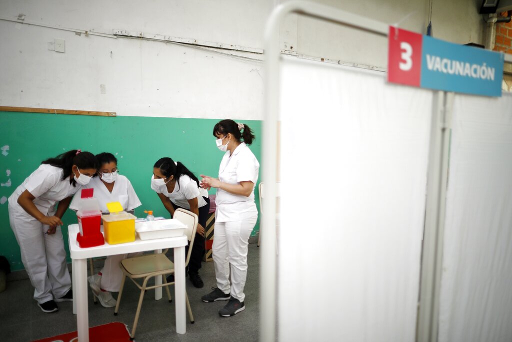 ARCHIVO - En esta foto de archivo del 18 de febrero de 2021, enfermeras leen instrucciones sobre cómo administrar la vacuna Sputnik V contra COVID-19 en una escuela pública de Bernal, en las afueras de Buenos Aires, Argentina. (AP Foto/Natacha Pisarenko, Archivo)