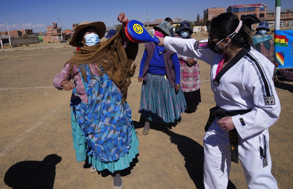 La instructora de taekwondo Laura Roca, derecha, practica con una mujer aymara durante un entrenamiento de defensa personal en El Alto, Bolivia, el jueves 22 de julio de 2021. (AP Foto/Juan Karita)