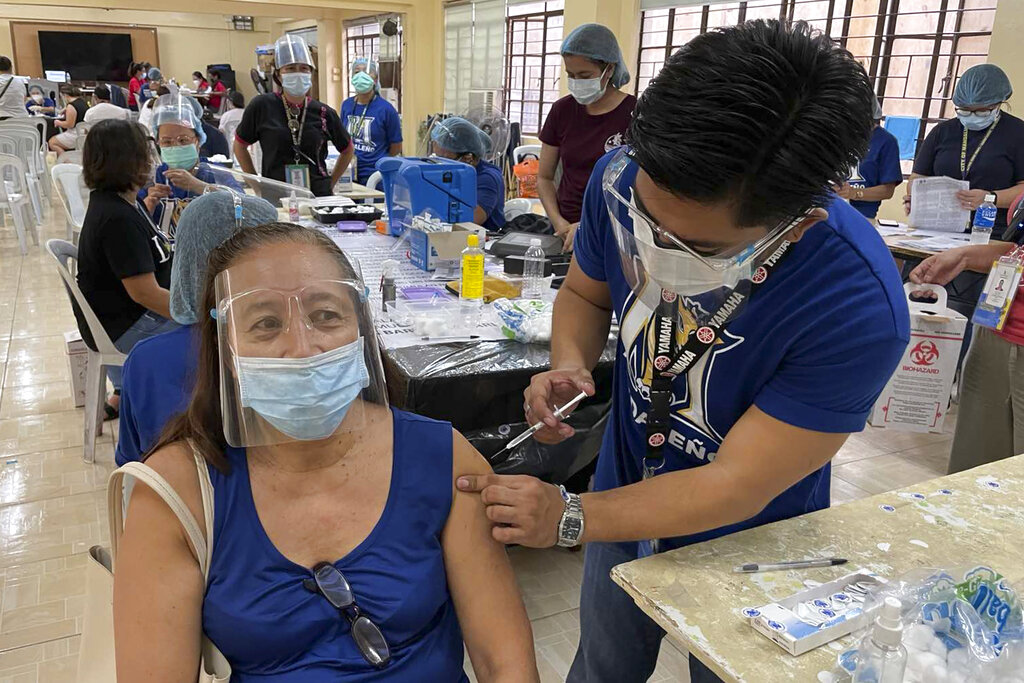 Una mujer recibe la vacuna de AstraZeneca contra el COVID-19 el viernes 23 de julio de 2021 en la ciudad de Mandaluyong, Filipinas. (AP Foto/Joeal Calupitan)