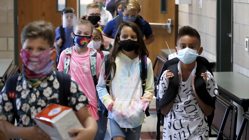 Wearing masks to prevent the spread of COVID19, elementary school students walk to classes to begin their school day in Godley, Texas, Wednesday, Aug. 5, 2020. Three rural school districts in Johnson County were among the first in Texas to head back to school for in person classes for students. (AP Photo/LM Otero)