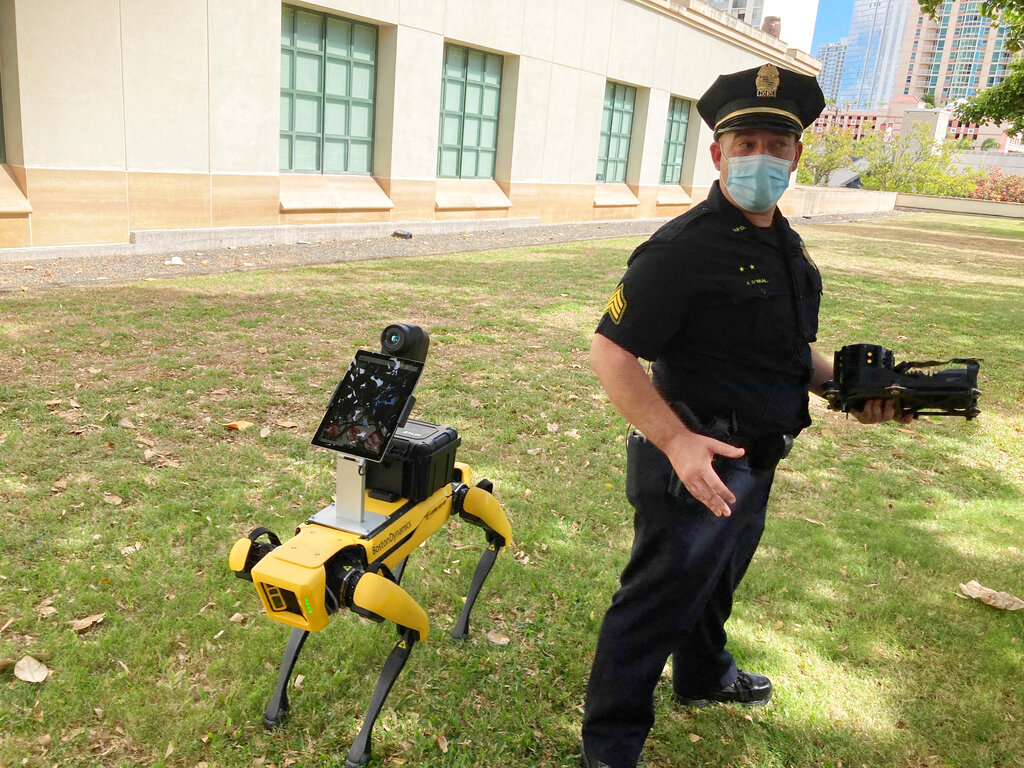 El teniente de la policía de Honolulu, Joseph O'Neal, demuestra un perro robot en Honolulu, 14 de mayo de 2021. Los agentes que utilizan de manera experimental las máquinas de cuatro patas dicen que son una herramienta más, como los drones, para evitar que los socorristas corran peligro en situaciones de emergencia. (AP Foto/Jennifer Sinco Kelleher)