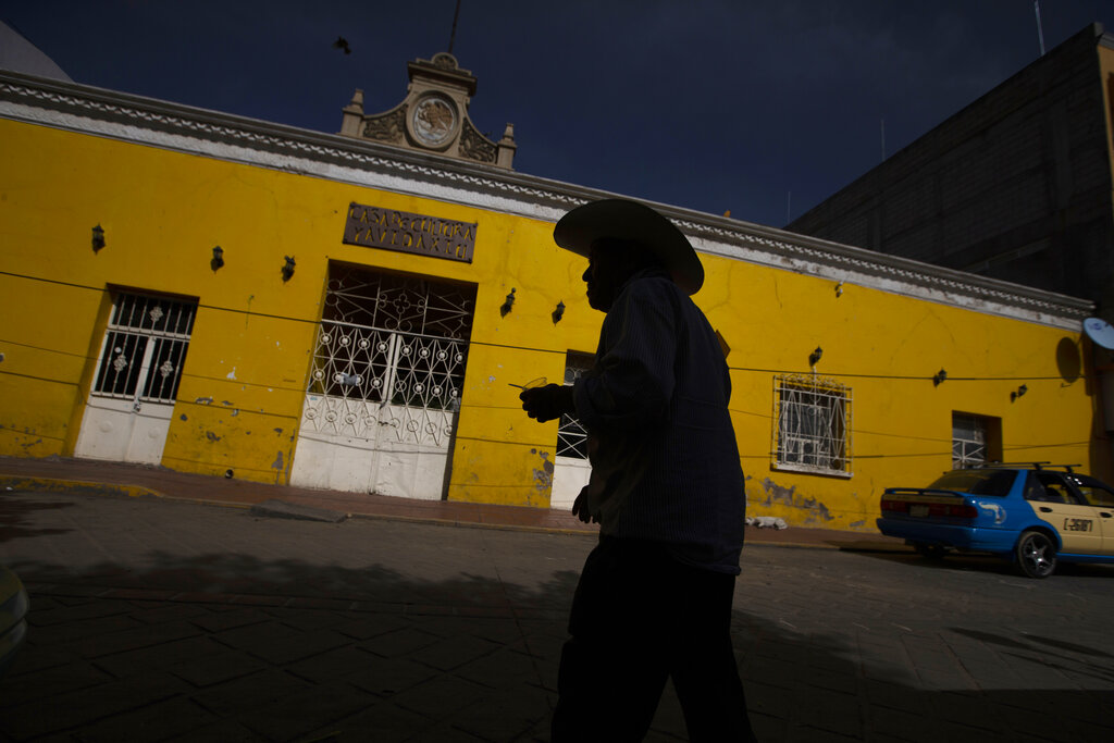 Esta fotografía de archivo del 27 de junio de 2020 muestra a un cliente saliendo de un banco en el que la gente recibe transferencias bancarias internacionales, en Acatlán de Osorio, México. (AP Foto/Fernando Llano, archivo)