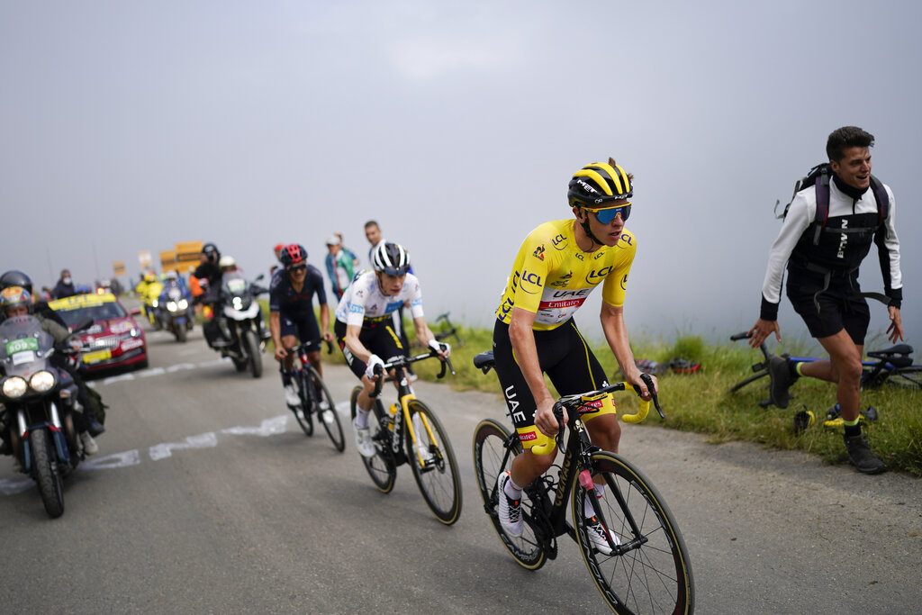 Tadej Pogacar, con el maillot amarillo, avanza por delante de Jonas Vingegaard y Richard Carapaz durante el ascenso al Col du Portet por la 17ma etapa del Tour de Francia, el miércoles 14 de julio de 2021. (AP Foto/Daniel Cole)