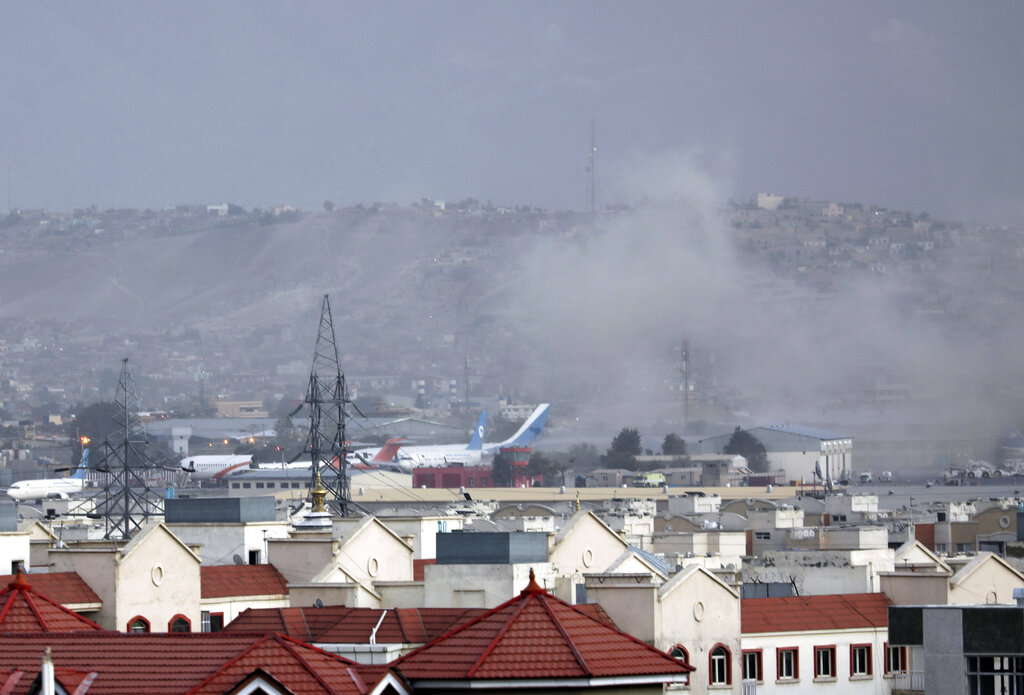 Se alza humo tras una explosión fuera del aeropuerto de Kabul, Afganistán jueves 26 de agosto de 2021. Las autoridades no dieron cifras, pero un testigo  que se encontraba a 30 metros del lugar dijo que vio varios muertos o heridos. (AP Foto/Wali Sabawoon)