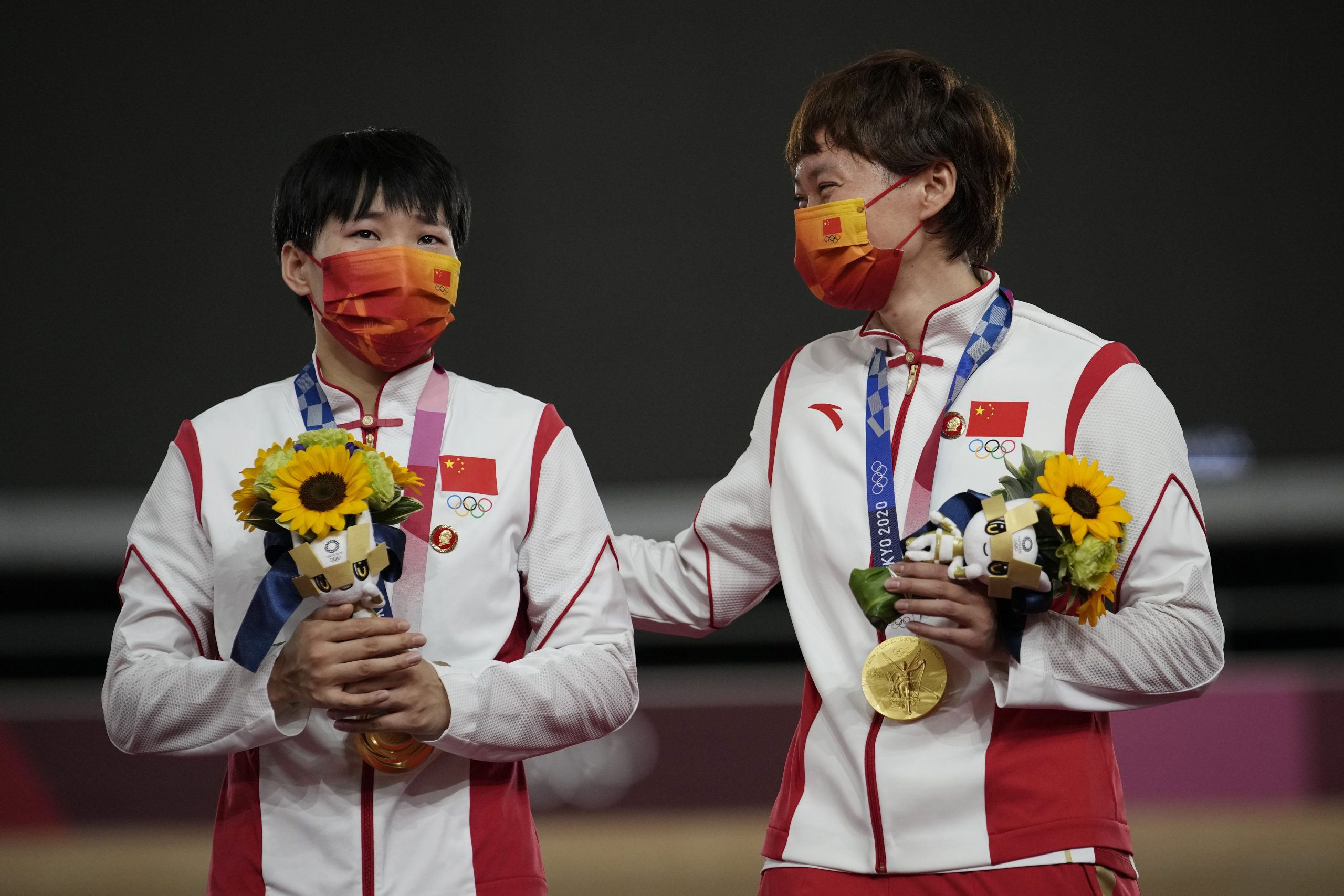 Las chinas Shanju Bao (izquierda) y Tianshi Zhong celebran su oro olímpico en velocidad por equipos en los Juegos de Tokio, el 2 de agosto de 2021, en Izu, Japón. (AP Foto/Christophe Ena)