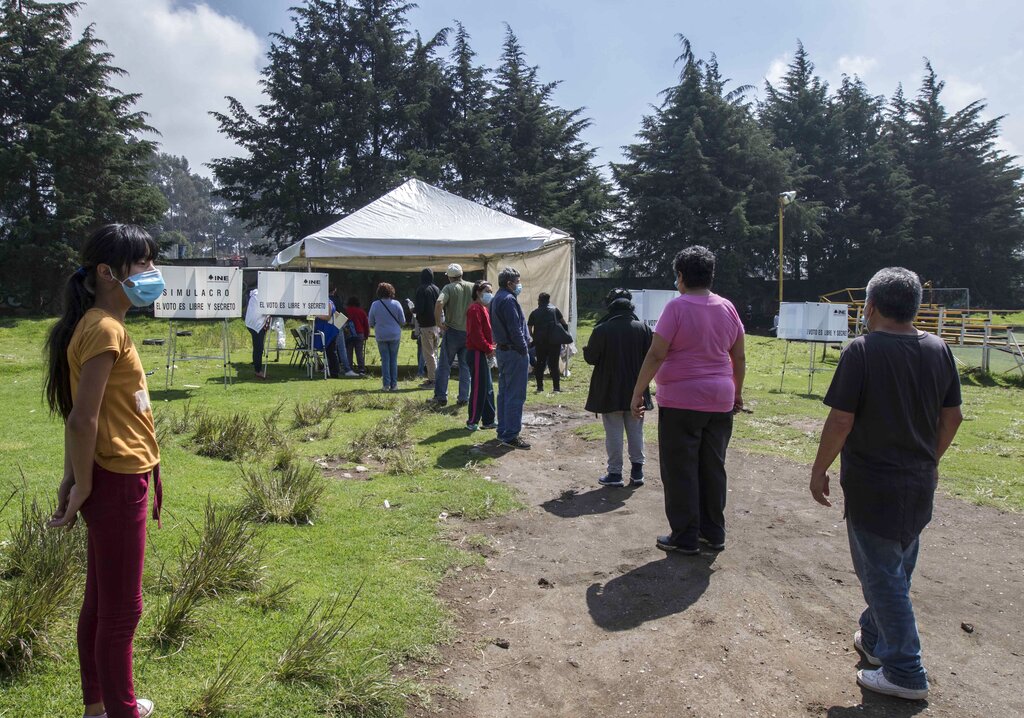 Varias personas se forman para emitir su voto en un referendo el domingo 1 de agosto de 2021, en San Miguel Topilejo, en la Ciudad de México. (AP Foto/Christian Palma)