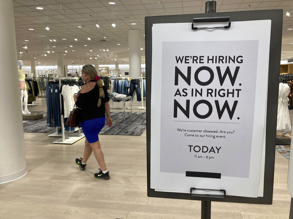 Una cliente camina detrás de un letrero sobre vacantes laborares en una tienda de Nordstrom, el viernes 21 de mayo de 2021 en Coral Gables, Florida. (Foto AP/Marta Lavandier)
