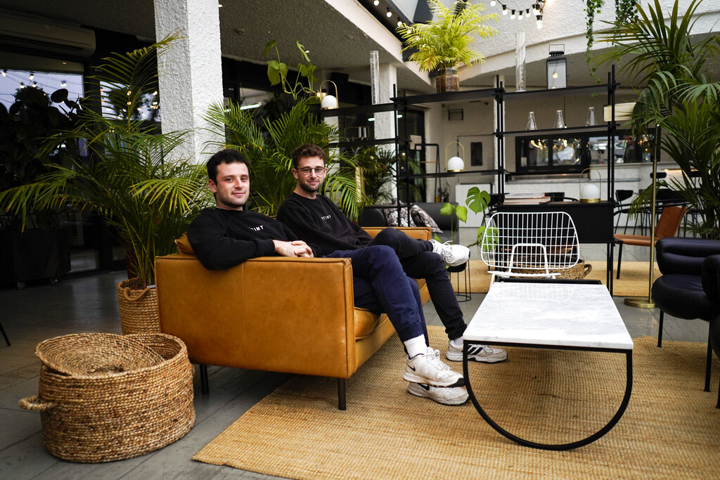 Los cofundadores del app Stint, los hermanos Sam y Sol Schlagman, están sentados en las oficinas de su compañía en Camden, Londres, el 23 de agosto del 2021. El app ayuda a la gente a encontrar empleos breves en diversas posiciones. (AP Foto/Alberto Pezzali)