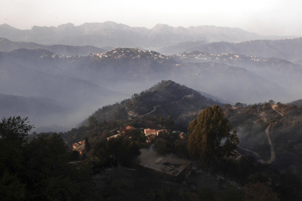 Humo de incendios cubre las montañas en la aldea de Larbaa Nath Irathen, cerca de Tizi Ouzou, en la región montañosa de Cabilia, a 100 kilómetros (60 millas) al este de Alger, la capital de Argelia, el miércoles 11 de agosto de 2021. (AP Foto/Fateh Guidoum)