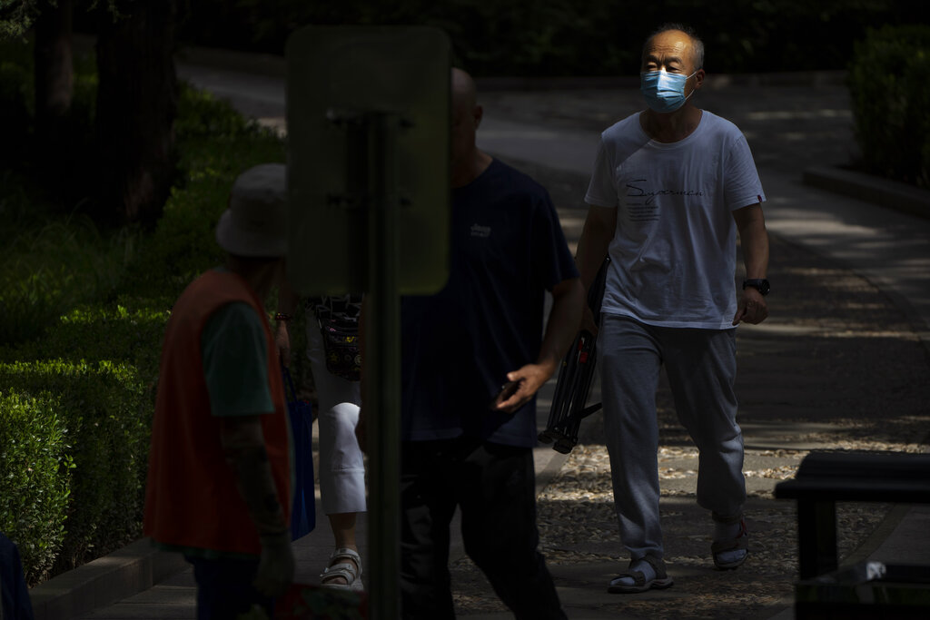 Un hombre, con mascarilla para protegerse del coronavirus, camina por un sendero en un parque público en Beijing, el 25 de agosto de 2021. (AP Foto/Mark Schiefelbein)