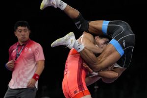 El japonés Shohei Yabiku, a la izquierda, y el iraní Mohammadali Geraei luchan por la medalla de bronce en la categoría de 77 kilos. (AP)