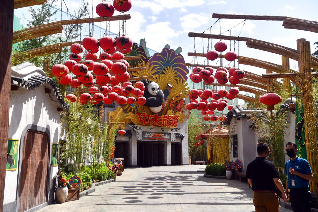 ARCHIVO - En esta foto del 26 de mayo de 2021, hombres con mascarillas en el parque temático Universal Studios, parte del Universal Beijing Resort en construcción en Beijing, China. Universal Studios anunció el lunes 30 de agosto de 2021 que el parque, su primero en el país, abrirá sus puertas el 20 de septiembre. (Chinatopix vía AP, Archivo)