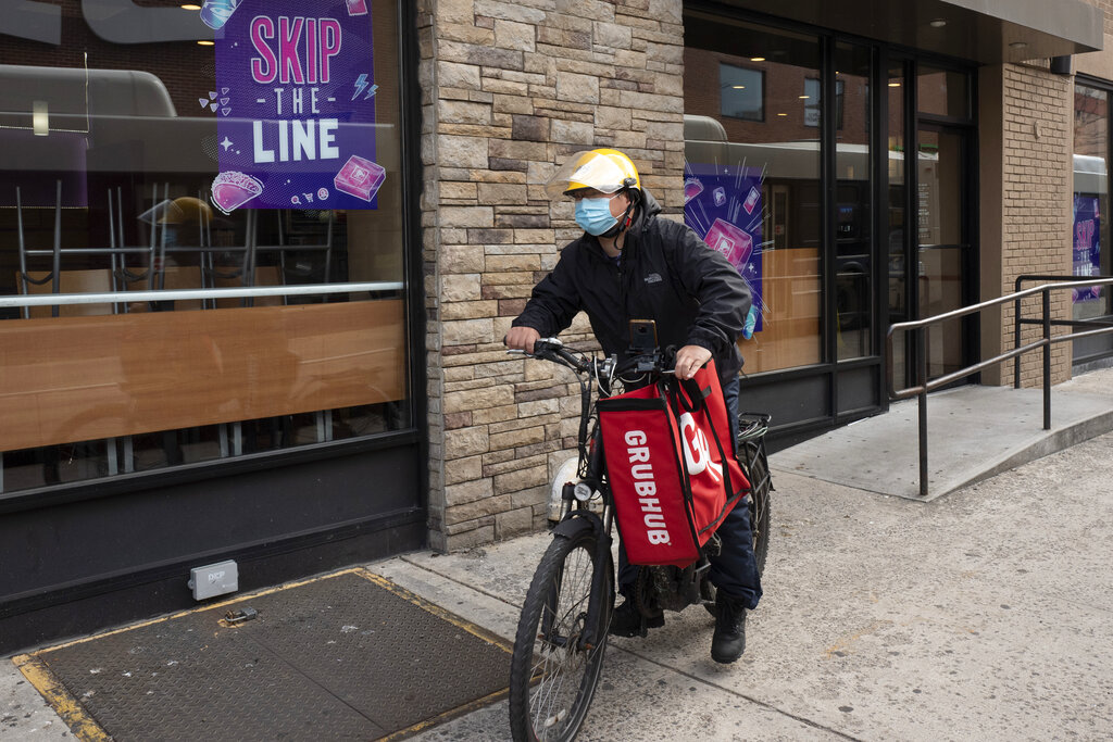 En esta foto del 21 de abril del 2021, un repartidor lleva una bolsa con comida de Grubhub en Nueva York. (AP)