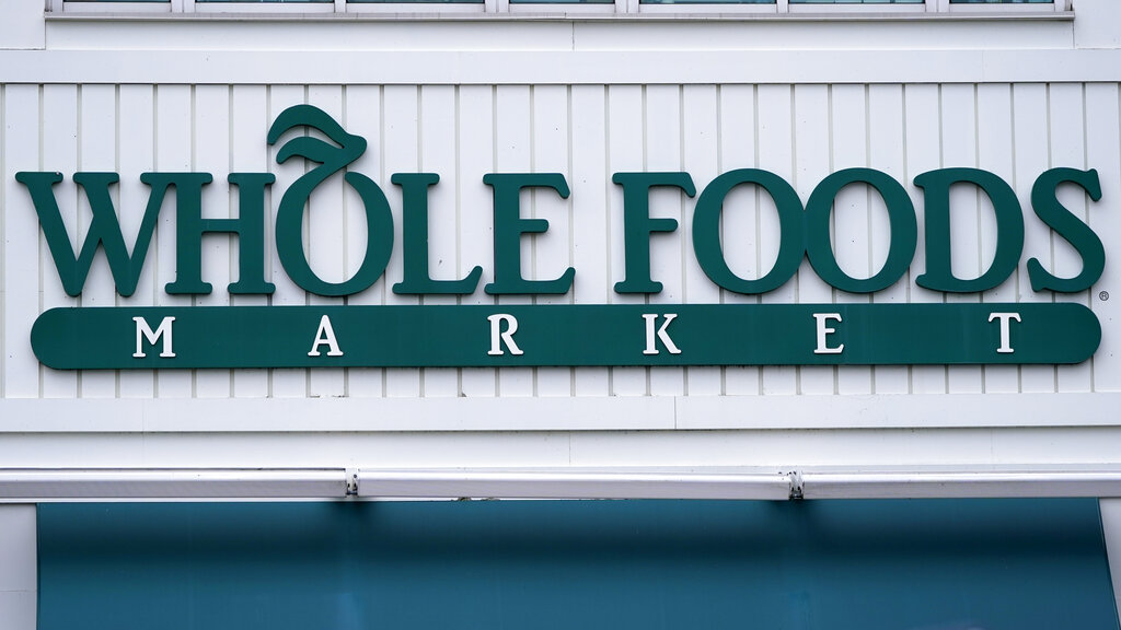En esta imagen del miércoles 14 de julio de 2021, se ve el logo de una tienda Whole Foods Market en Cambridge, Massachusetts.  (AP Foto/Charles Krupa)
