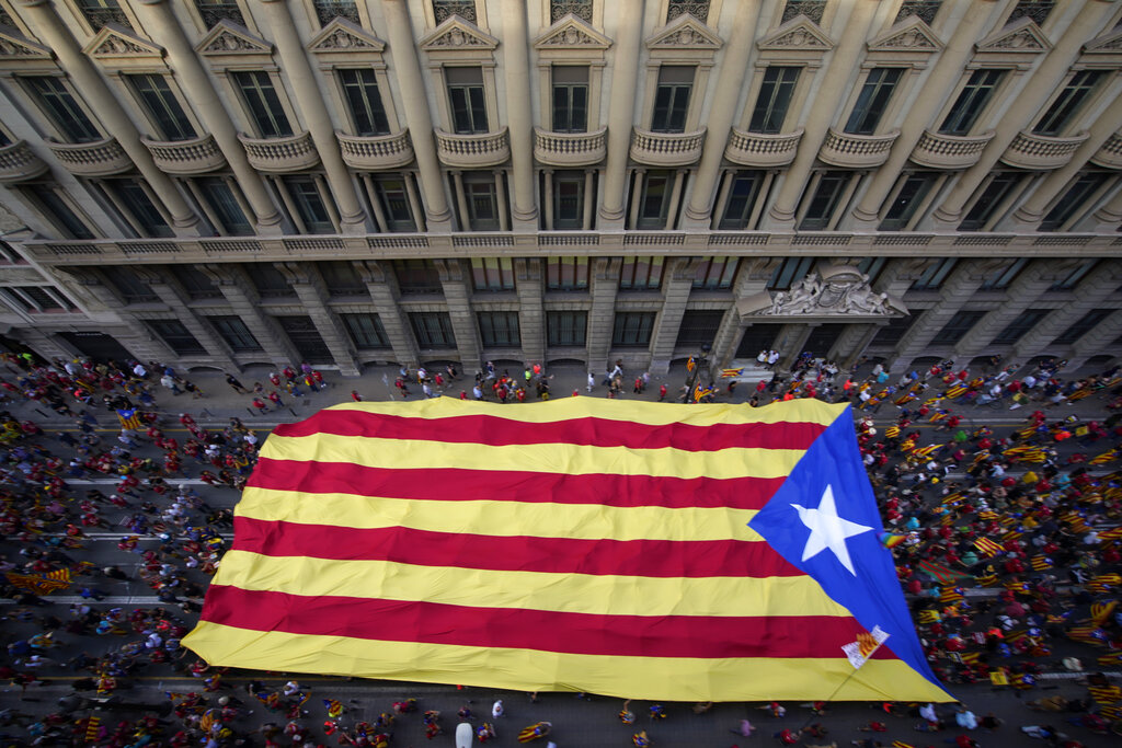 Manifestantes marchan con una gran bandera independentista en el Día Nacional de Cataluña en Barcelona, España, 11 de setiembre de 2021. ( AP)