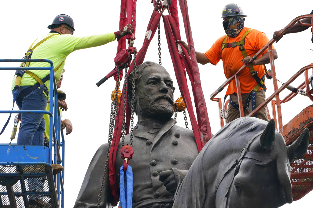 Cuadrillas sujetan con correas la estatua del general de la Confederación Robert E. Lee para retirarla de su pedestal, uno de los monumentos más grandes que aún subsisten a la causa del sur esclavista, en la Avenida de los Monumentos de Richmond, Virginia, miércoles 8 de setiembre de 2021. (AP Foto/Steve Helber, Pool)