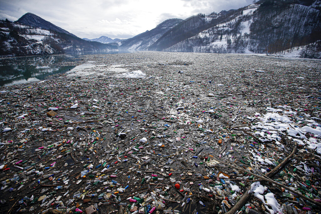 En esta fotografía del viernes 22 de enero de 2021, botellas de plástico y otros desechos flotan en el lago Potpecko, en Serbia. (AP)
