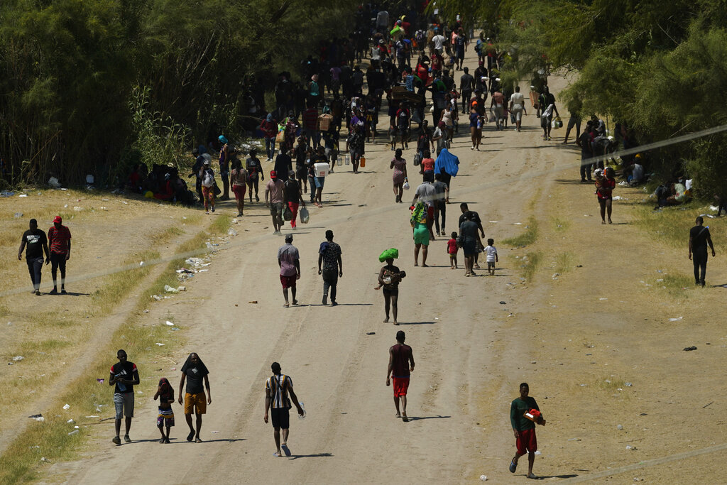 Migrantes haitianos caminan por un camino de tierra después de ingresar a Estados Unidos desde México, el viernes 17 de septiembre de 2021, en Del Rio, Texas. (AP)