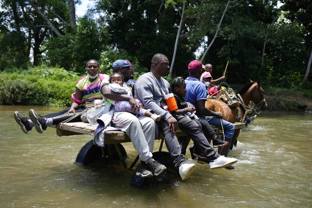 Migrantes cruzan el Río Acandi cerca de Acandi en Colombia el 14 de septiembre del 2021. Los migrantes, en su mayoría haitianos, tratan de llegar a Darién en Panamá y de allí partir hacia Estados Unidos. (AP)