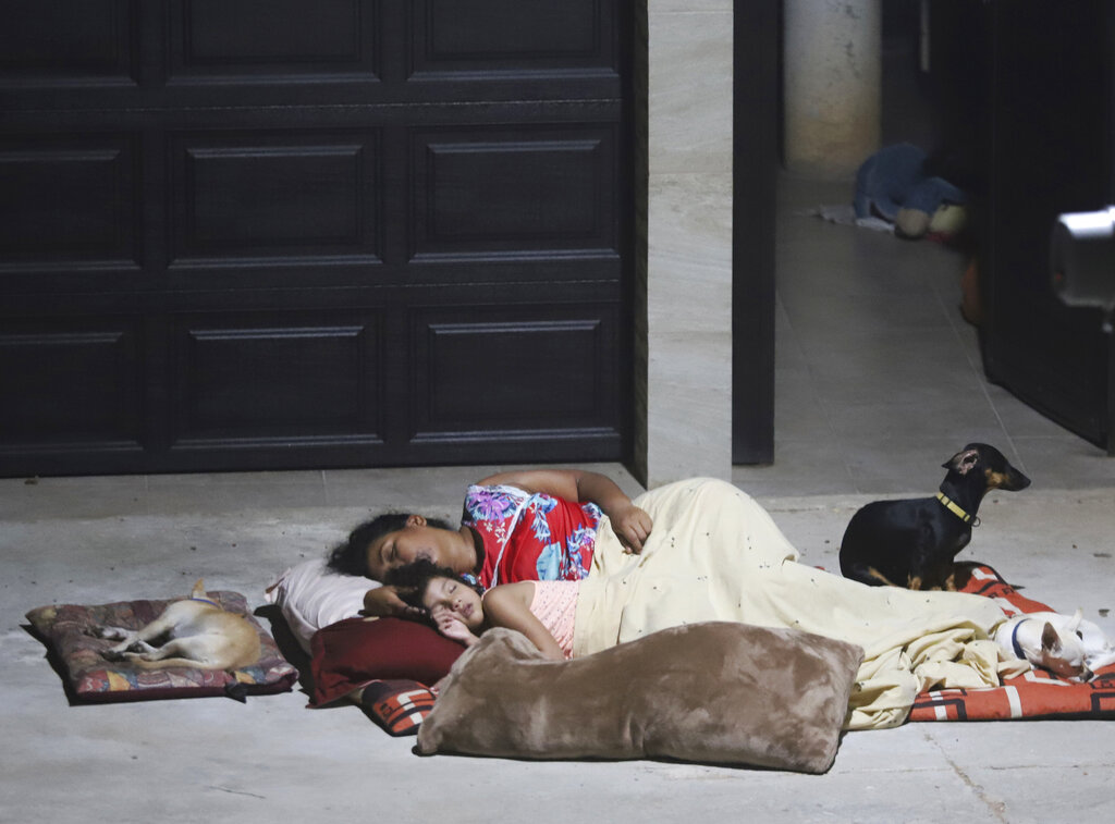 Una mujer y una niña duermen afuera de su casa el miércoles 8 de septiembre de 2021 tras un terremoto, en Acapulco, México. (AP)