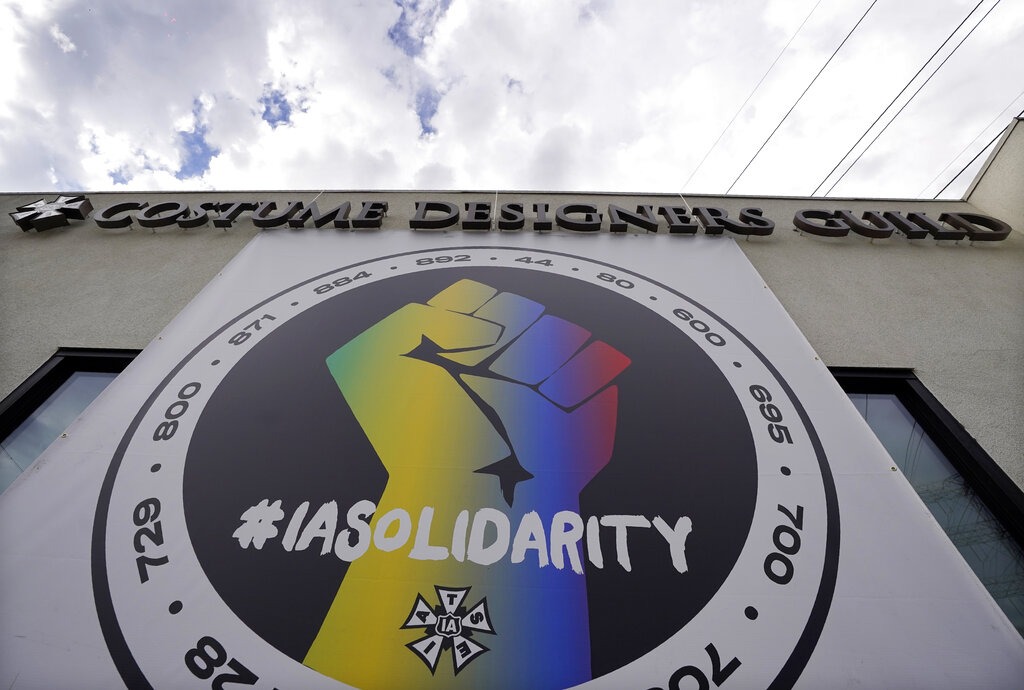 Un póster que llama a la solidaridad sindical cuelga de un edificio que alberga oficinas de la Alianza Internacional de Empleados de Escenarios Teatrales (IATSE). (AP)