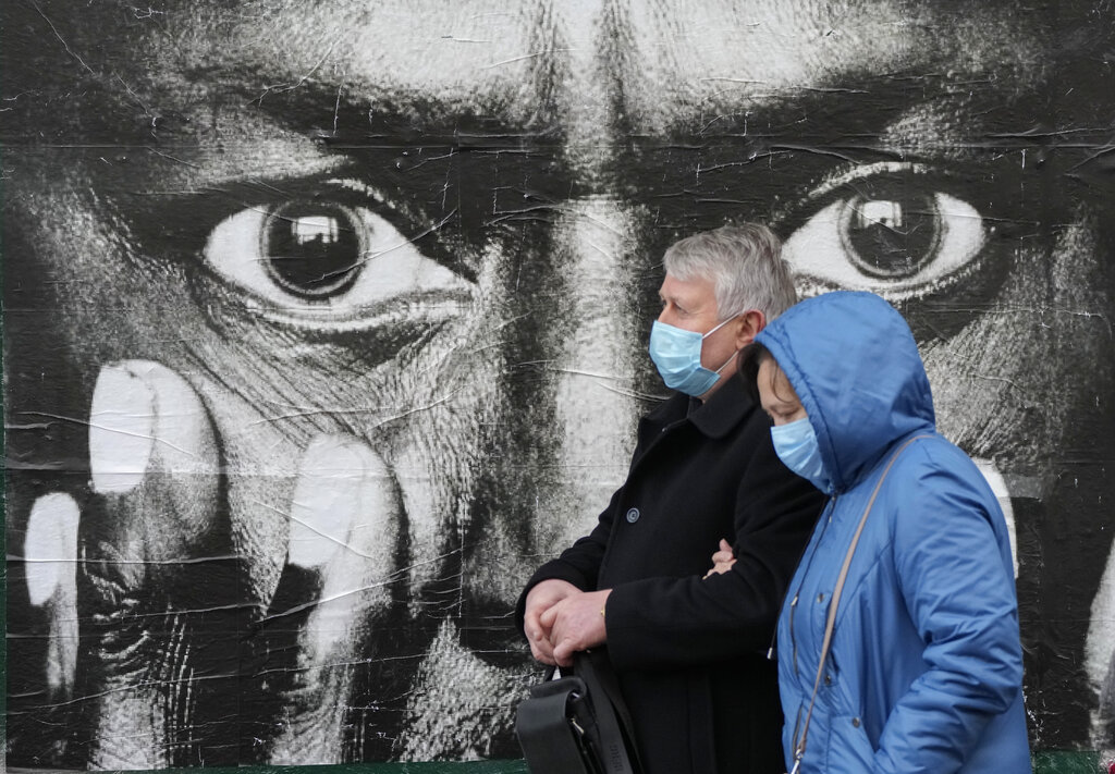 Dos personas, con mascarilla para protegerse del coronavirus, caminan por la calle Khreshchatyk, en Kiev, Ucrania, el 9 de noviembre de 2021. (AP)