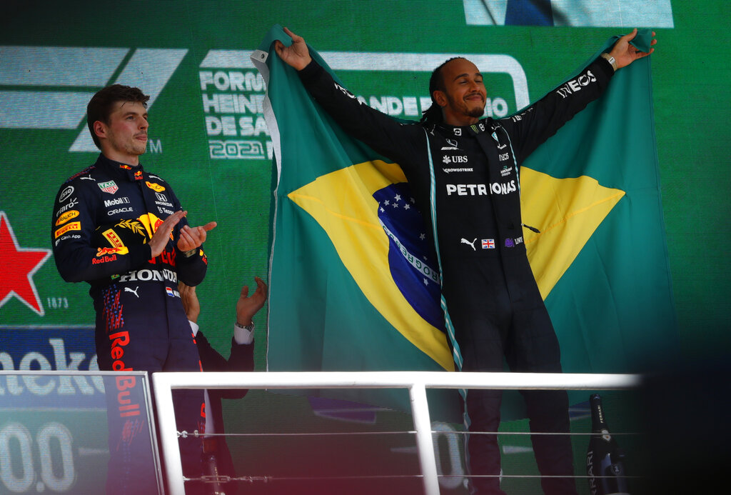 El piloto de Mercedes Lewis Hamilton celebra su triunfo en el Gran Premio de Brasil, junto a Max Verstappen de Red Bull que quedó segundo en la carrera, el domingo 14 de noviembre de 2021. (AP)