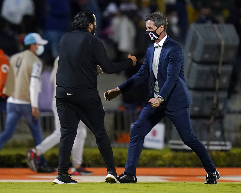 El técnico de Atlas Diego Cocca (derecha) celebra tras la victoria 1-0 ante Pumas en las semifinales del torneo Apertura de México, el jueves 2 de diciembre de 2021. (AP)