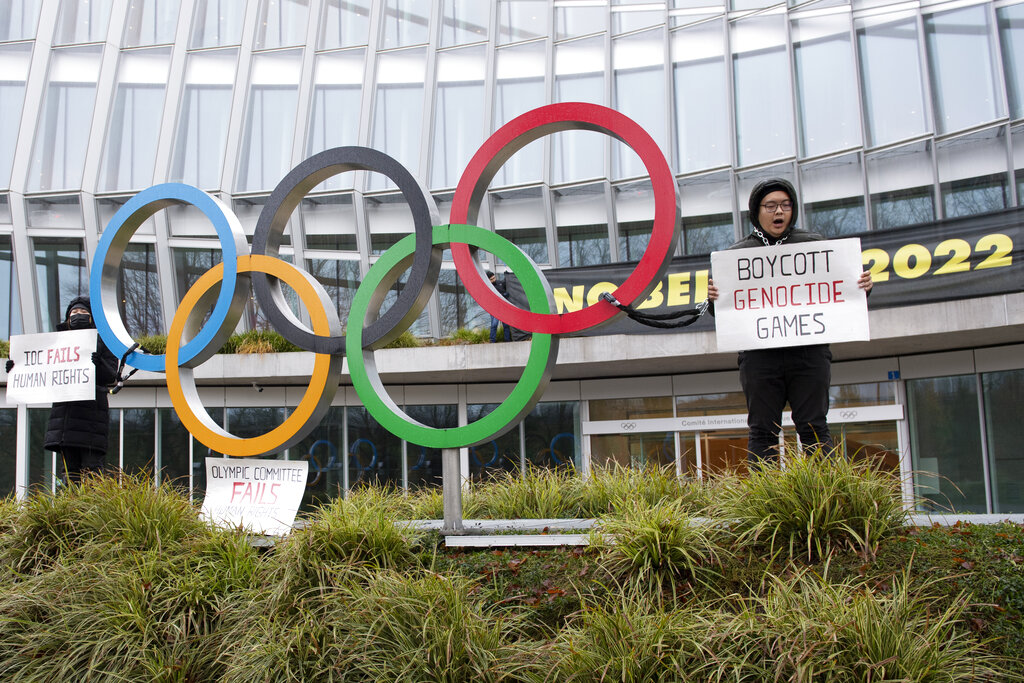 Manifestantes sostienen letreros durante una protesta contra la realización de los Juegos Olímpicos de Invierno de Beijing de 2022. (AP)