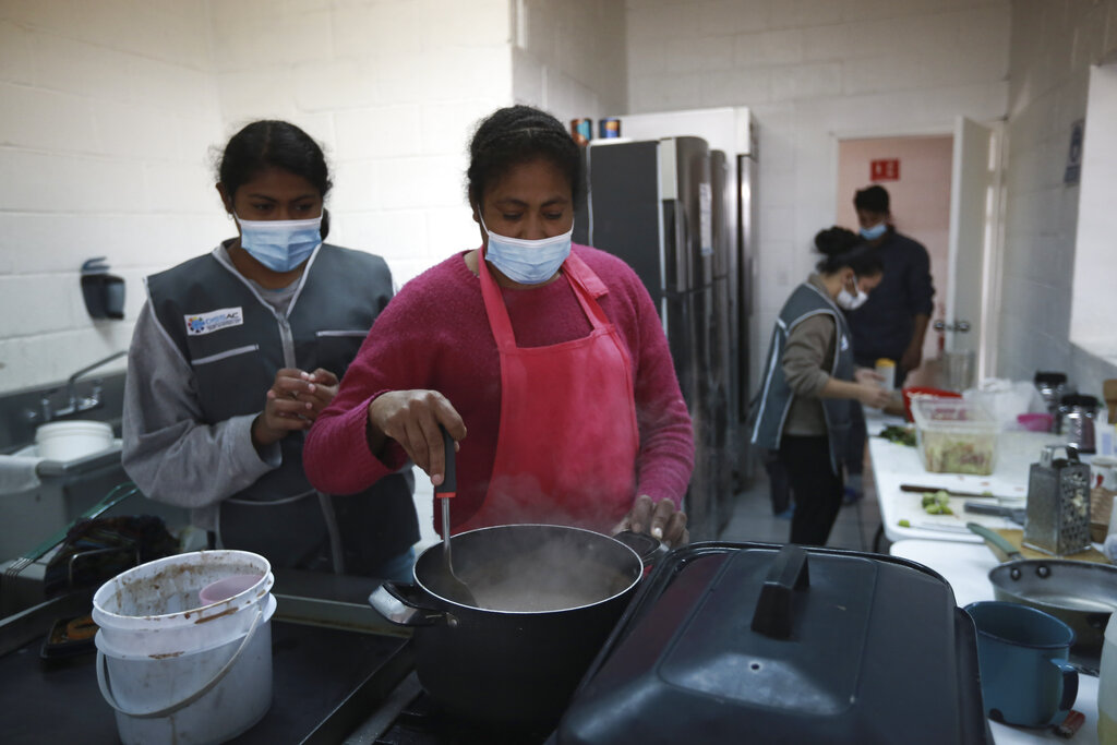 Migrantes preparan alimentos en el albergue San Matías, en Ciudad Juárez, México, el miércoles 9 de febrero de 2022. (AP)