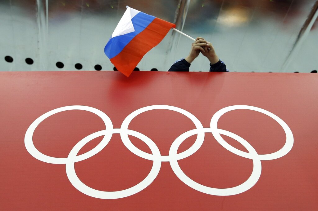 Una bandera rusa ondea sobre los anillos olímpicos en el centro de patinaje Adler Arena, durante los Juegos Olímpicos de Invierno de Sochi, Rusia, el 18 de febrero de 2014. (AP)