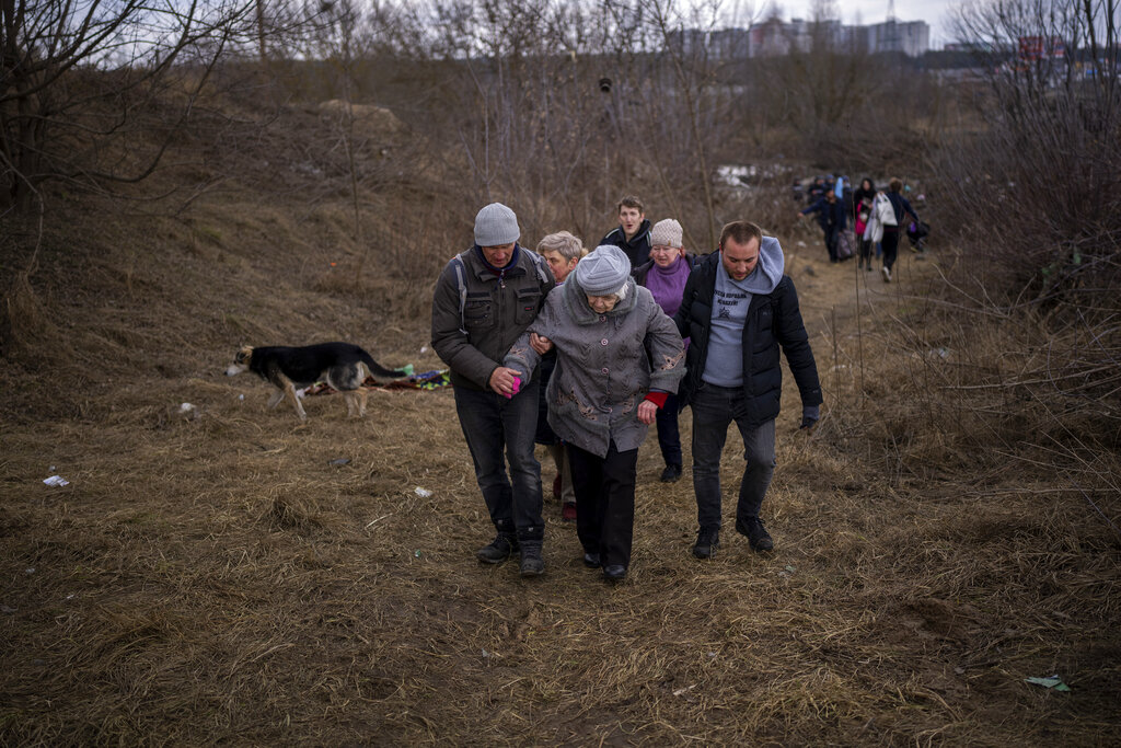 Gente huyendo de Irpin, a las afueras de Kiev, Ucrania, el lunes 7 de marzo de 2022, mientras se oye artillería cerca. (AP)