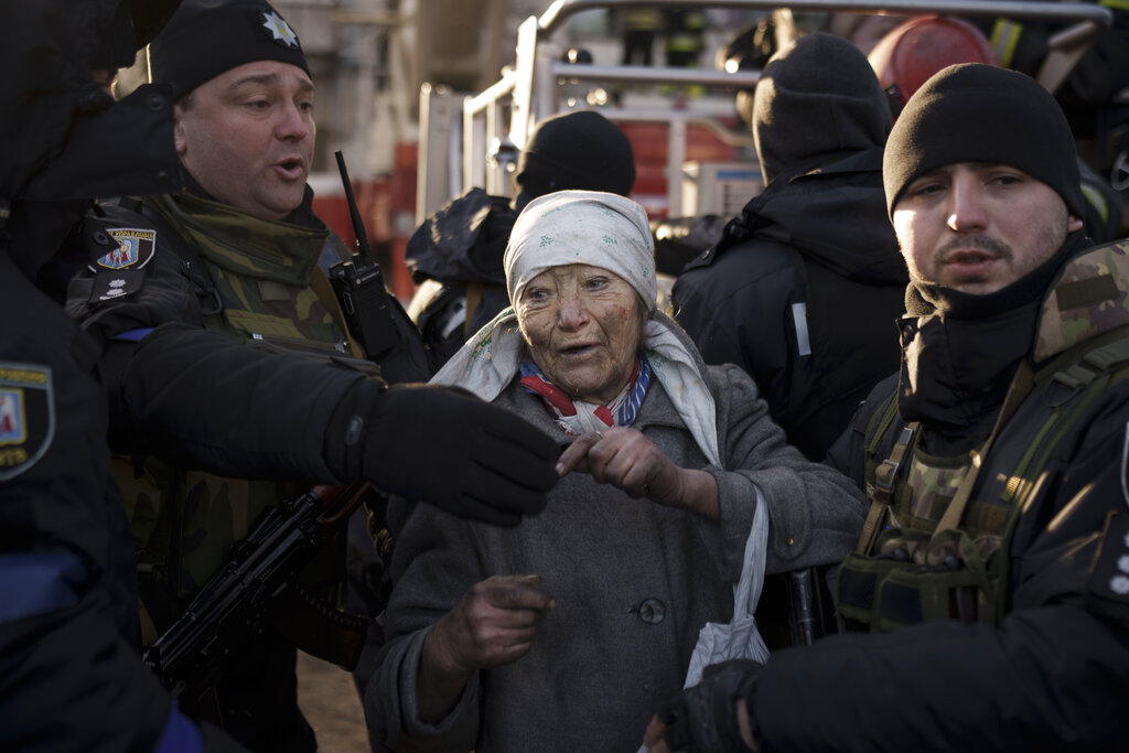 Una anciana recibe ayuda de policías tras ser rescatada por los bomberos de su apartamento tras un bombardeo en Kiev, Ucrania, el martes 15 de marzo de 2022. (AP)