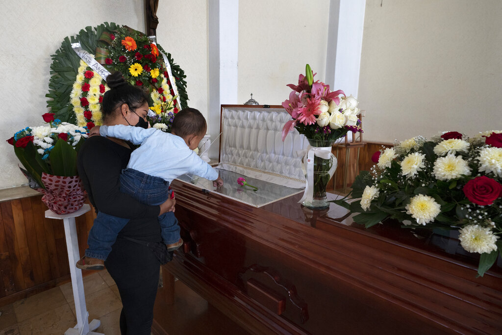Un nieto se sostiene sobre el ataúd abierto que contiene los restos de su abuelo, el periodista asesinado Armando Linares, en Zitácuaro, en el estado de Michoacán, México, el miércoles 16 de marzo de 2022. (AP)