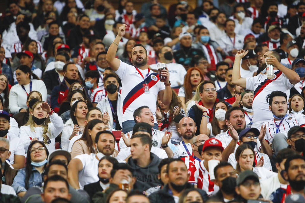 Seguidores alientan a las Chivas durante el clásico del fútbol mexicano ante el América, el sábado 12 de marzo de 2022. (AP)