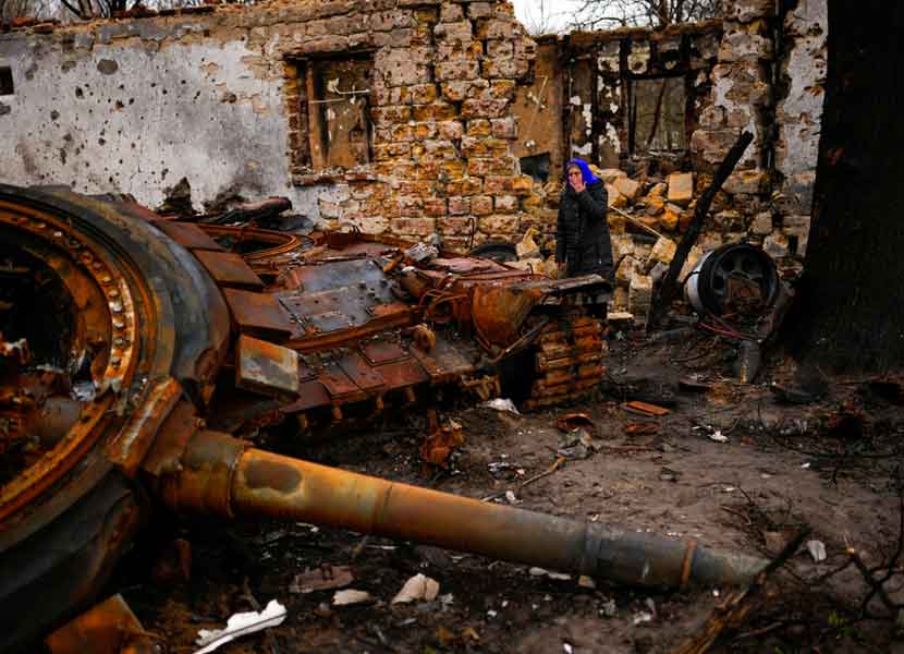 Valentyna Sherba, de 68 años, está junto a un tanque de Rusia en el patio trasero de la casa de su padre, ambos destruidos. / Foto: AP