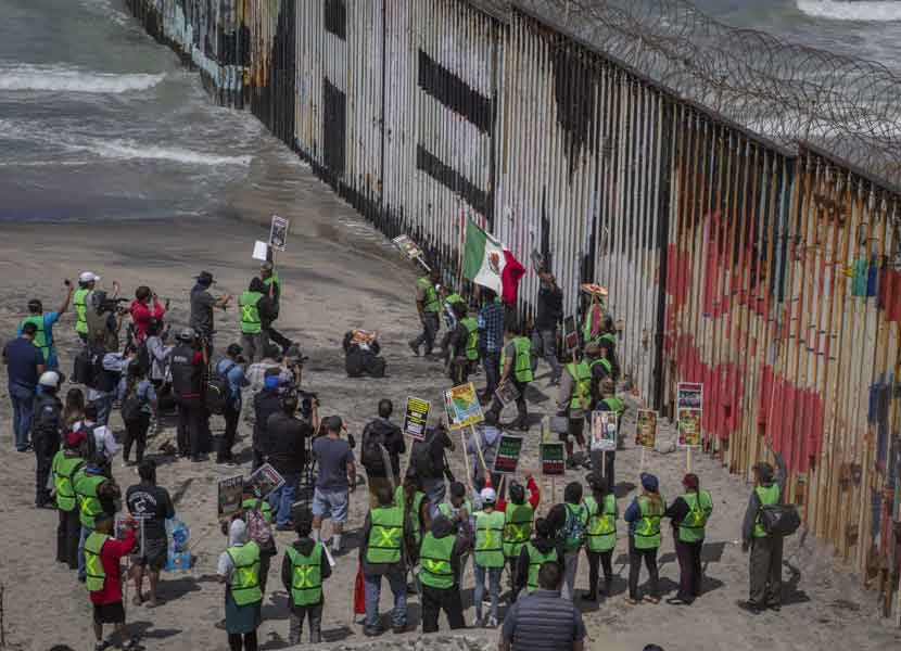 Integrantes de la “Alianza Migrante” se manifestaron enfrente del muro fronterizo. / Foto: Cuartoscuro