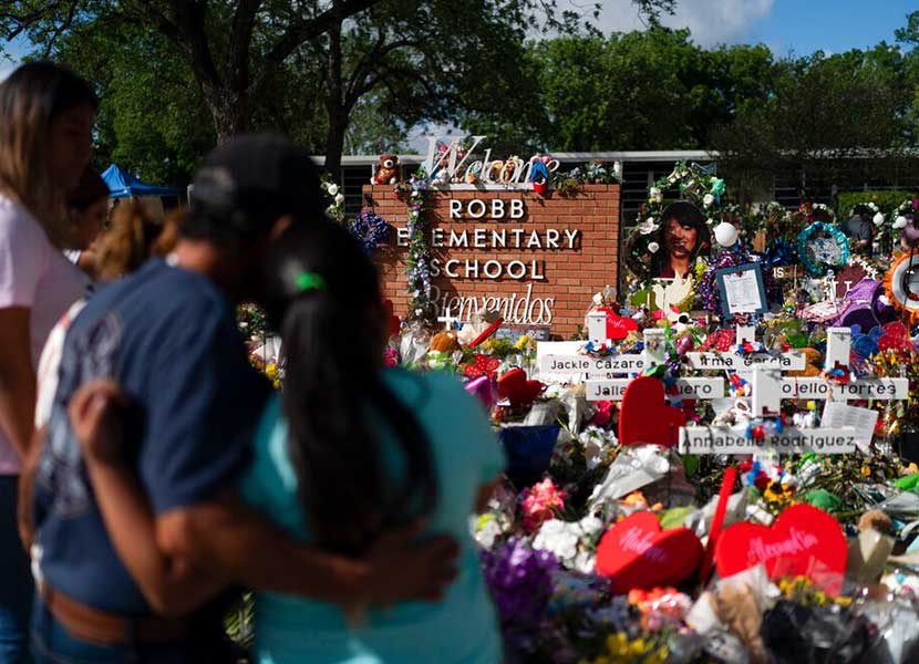 Familiares visitan un monumento conmemorativo el cual fue erigido en honor de las personas asesinadas en la Escuela Primaria Robb, en Uvalde, Texas.