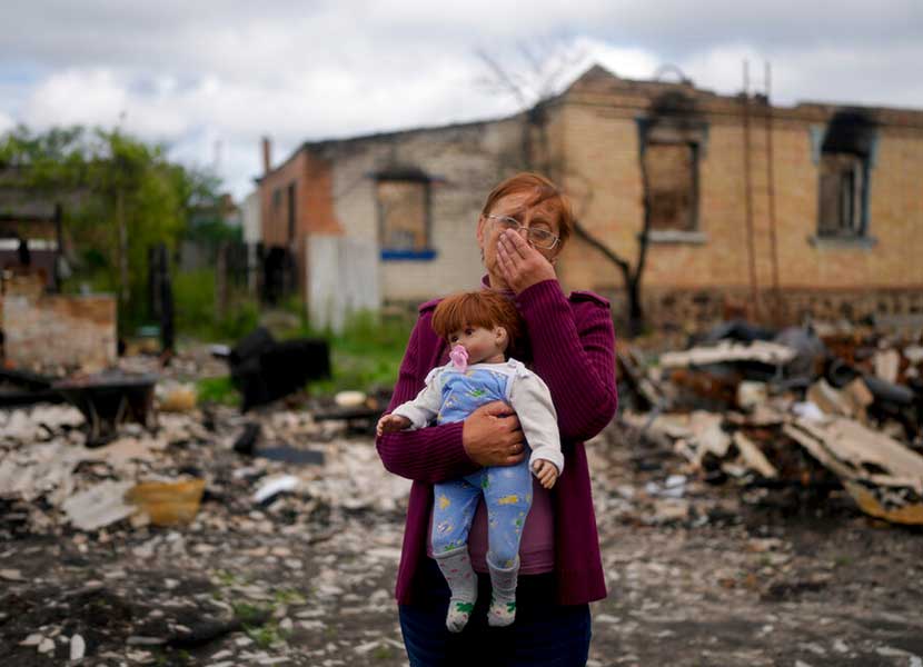 Nila Zelinska sostiene una muñeca de su nieta que encontró en su casa destruida por artillería rusa en las afueras de Potashnya, Kiev, Ucrania. / AP
