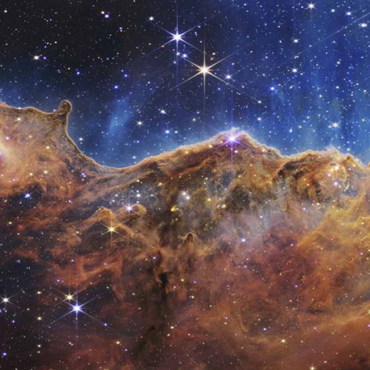 Lo que se parece mucho a montañas escarpadas en una noche iluminada por la luna es en realidad el borde de una joven región cercana de formación estelar NGC 3324 en la Nebulosa Carina. / Foto: NASA