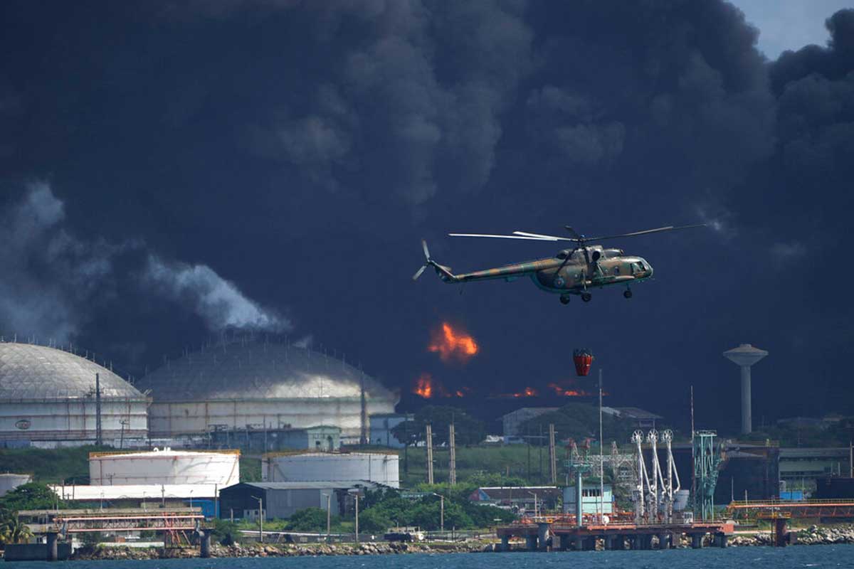 Un helicóptero arroja agua sobre la Base de Supertanqueros de Matanzas. AP