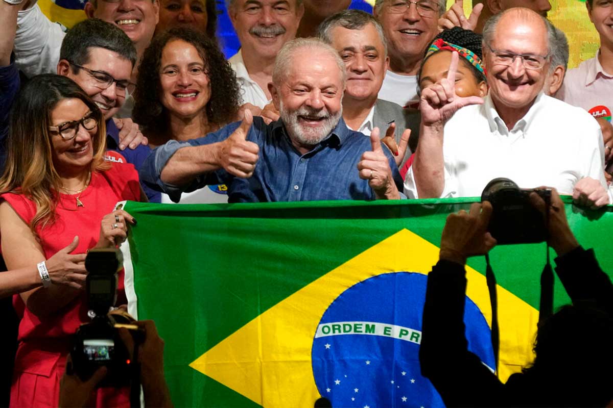 El expresidente brasileño Luiz Inácio Lula da Silva festeja con su esposa Rosangela Silva, izquierda, y su compañero de fórmula Geraldo Alckmin, derecha. / AP